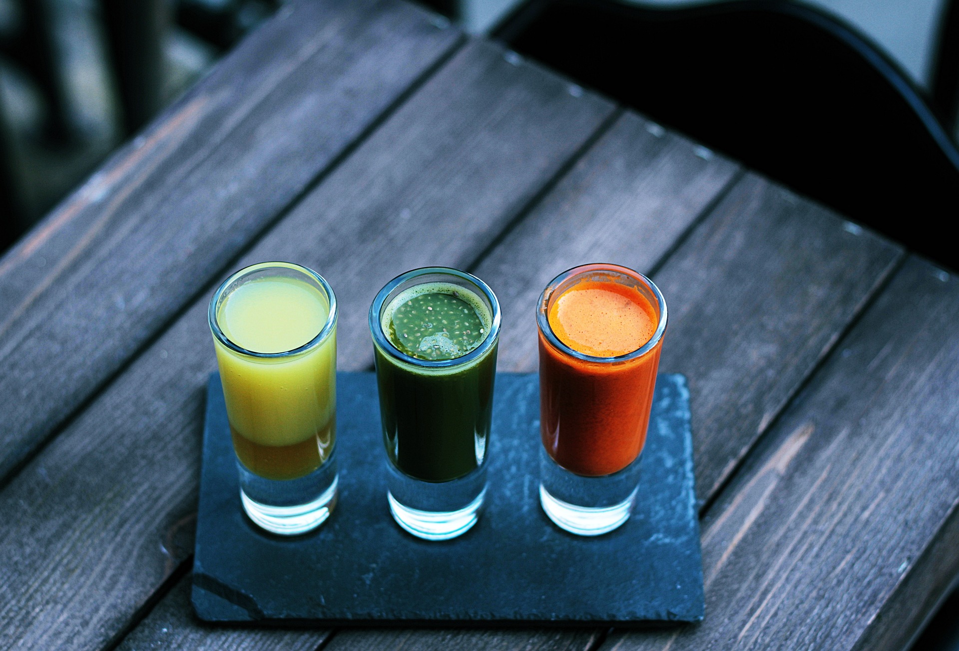 trzy szklanki ze świeżo wyciskanymi sokami owocowymi